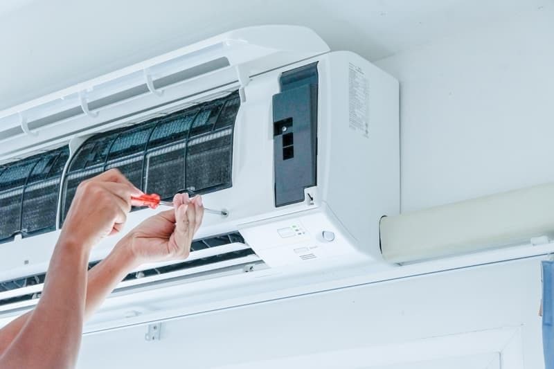 técnico reparando un aire acondicionado interior